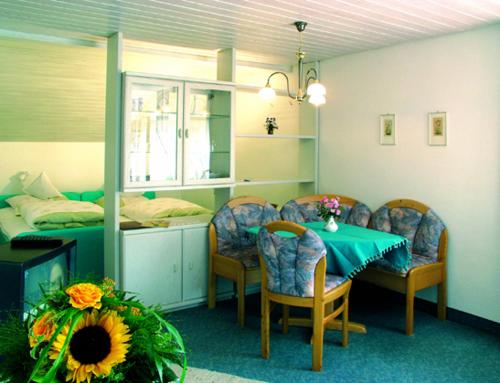 Cette chambre comprend une table, des chaises et un lit. dans l'établissement Kurhotel Weber, à Bad Wörishofen