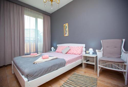 - une petite chambre avec un lit et une chaise dans l'établissement Tbilisi LOA Apartment, à Tbilissi