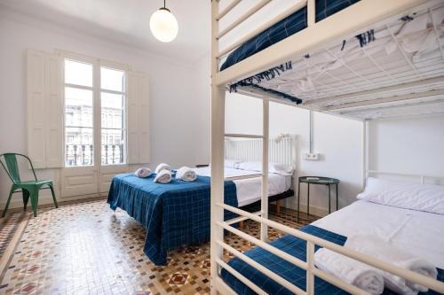 1 dormitorio con 2 literas y mesa en Sunny and Modernist apartment for groups in center, en Barcelona
