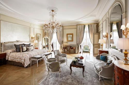 Habitación grande con cama y lámpara de araña. en Le Meurice – Dorchester Collection, en París