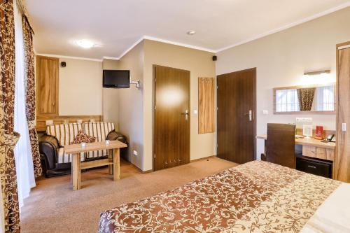 a hotel room with a bed and a couch at Hotel Dębowe Wzgórze Wellness & Spa in Jarnołtówek