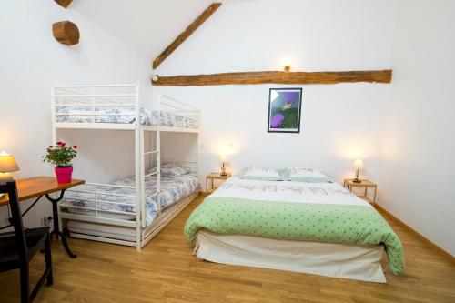 ein Schlafzimmer mit einem Bett, einem Schreibtisch und einem Regal in der Unterkunft Chambres d'hôtes Entre Dolmens et Fontaines in Buzeins