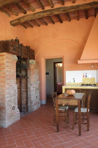 a dining room with a table and a kitchen at Agriturismo Podere La Casa in Palaia