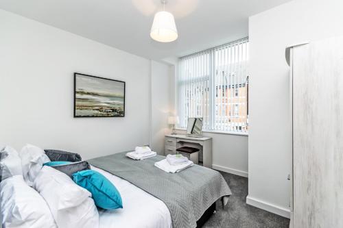 a bedroom with a bed with blue pillows at City Suites in Chester