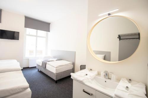 a bathroom with two beds and a mirror and a sink at Narodni Stay in Prague