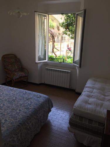 1 dormitorio con cama, ventana y silla en A un passo dalle 5 Terre, en Moneglia