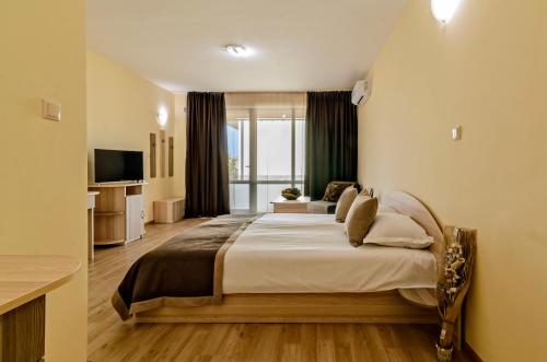 een slaapkamer met een groot bed in een kamer bij Alex Village in Shkorpilovtsi