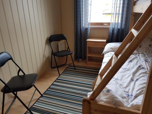 a bedroom with a bunk bed and a desk and two chairs at Lofoten Beach Camp in Ramberg