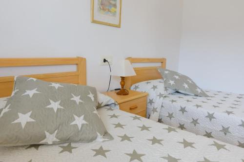 サロウにあるSant Jordi Zeus Basicのベッドルーム1室(グレーと白の星が特徴のベッド2台付)