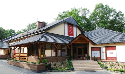 a building with a store with a sign on it at Hotel Dębowe Wzgórze Wellness & Spa - zarezerwuj w maju 2 noclegi a wypożyczenie rowerów będzie GRATIS! in Jarnołtówek