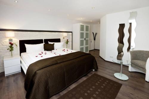 a bedroom with a large bed with red roses on it at City Apart Hotel Füssen in Füssen