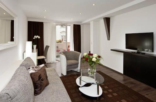 a living room with a couch and a tv at City Apart Hotel Füssen in Füssen