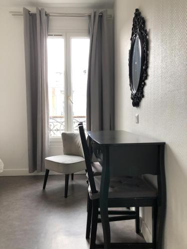 a table and a chair in a room with a window at Hotel Europe BLV in Paris