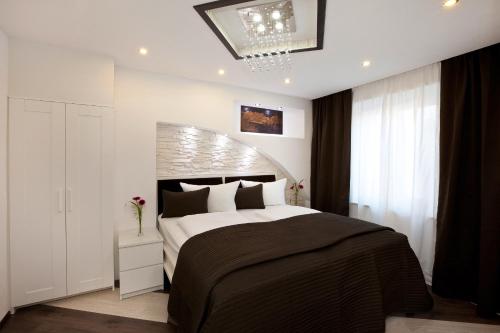 a bedroom with a large bed and a chandelier at City Apart Hotel Füssen in Füssen