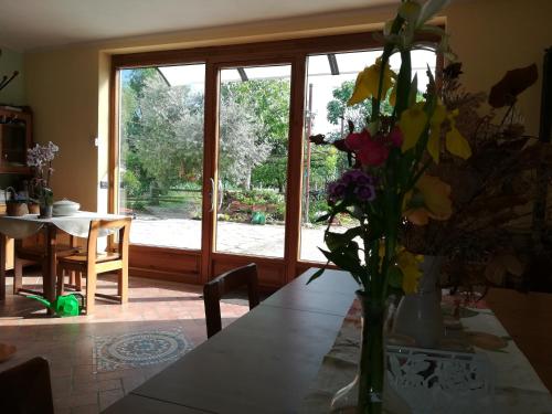 una mesa con un jarrón de flores encima en Agriturismo Loghino Sabbioni, en Suzzara