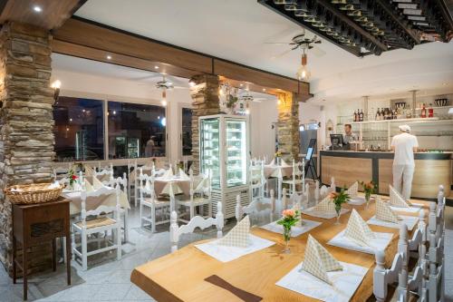 a restaurant with white tables and chairs and a counter at Hotel Esperia in Caorle