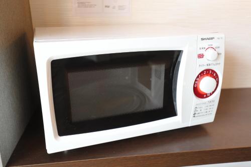 a white microwave oven with a red knob at EIWA PLACE HOTEL HAKATA - Former Hotel Ninestates Hakata in Fukuoka