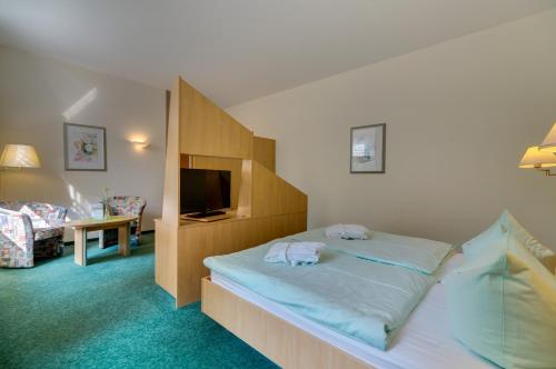 バート・シュレーマにあるKurhotel Bad Schlemaのベッドとテレビ付きのホテルルーム