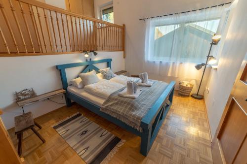 a bedroom with a blue bed and a window at Haus Agnes, Murau in Murau