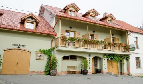 a building with a balcony with plants on it at Penzion a vinařství U Vrbů in Hustopeče