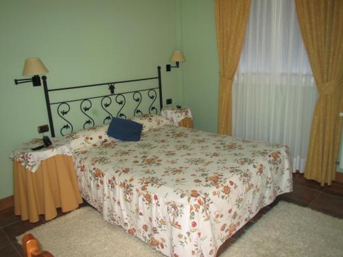 a bedroom with a bed with a floral bedspread at Hotel Ermintxo in Ea