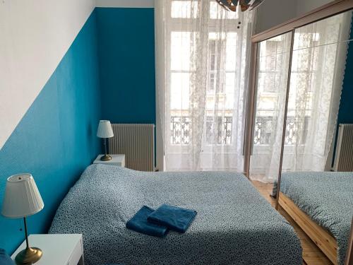- une chambre bleue avec 2 lits et une fenêtre dans l'établissement 020 CHIC & COSY GRAND APPART 57m2 HYPERCENTRE WIFI SMART TV NETFLIX, à Saint-Étienne