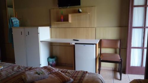 a kitchen with a counter and a chair in a room at Pousada Juriti - Eco Hotel in São Roque