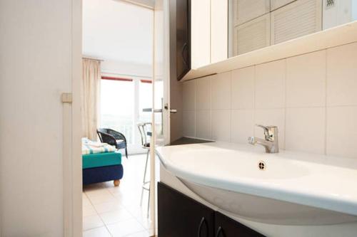 uma casa de banho com um lavatório branco e uma janela em ParkView Apartment 1 em Berlim