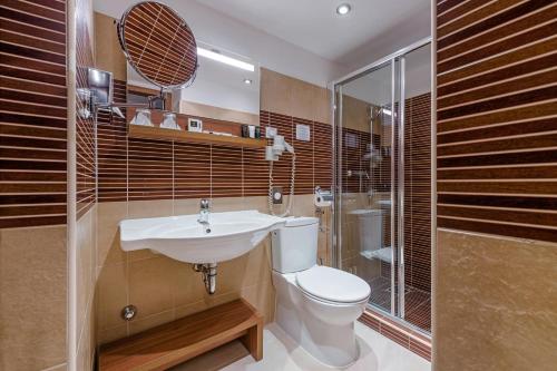 a bathroom with a toilet and a sink and a shower at Charm Hotel Budapest - formerly Boutique Hotel Budapest in Budapest