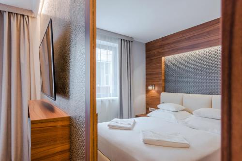 a hotel room with a bed and a mirror at Boutique Hotel Budapest in Budapest