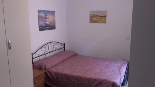 um quarto com uma cama e duas fotografias na parede em Monolocale Marola em La Spezia