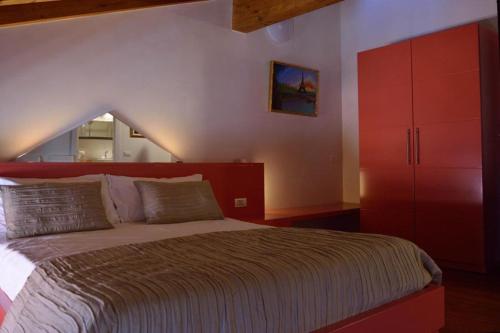 a bedroom with a large bed and a red cabinet at AmaMantua in Mantova