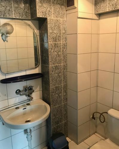een badkamer met een wastafel en een spiegel bij Zajazd Batory in Chorzów