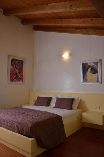 a bedroom with a bed and two paintings on the wall at AmaMantua in Mantova