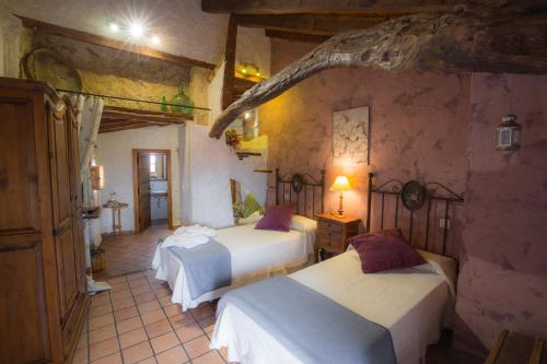 a bedroom with three beds in a room at Casa Rural & Spa La Graja in Chinchón