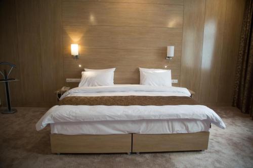 a bedroom with a large bed with a wooden headboard at Hotel Uzbekistan in Urganch