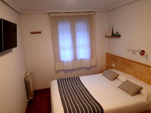 a bedroom with a bed and a window at Pensión Urkia in Donostia-San Sebastián