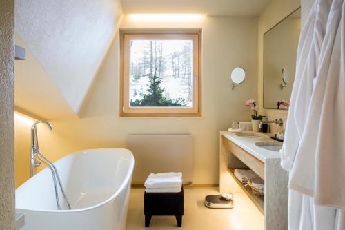 a bathroom with a tub and two sinks and a window at Hotel Hermitage Relais & Châteaux in Breuil-Cervinia