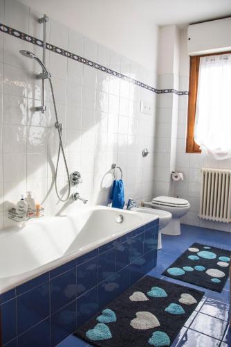 a blue and white bathroom with a tub and a toilet at CHIC PANORAMIC APARTMENT in Bergamo