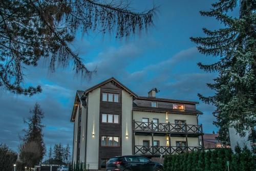 a house with a car parked in front of it at Old Tree Villa & Restaurant in Oświęcim