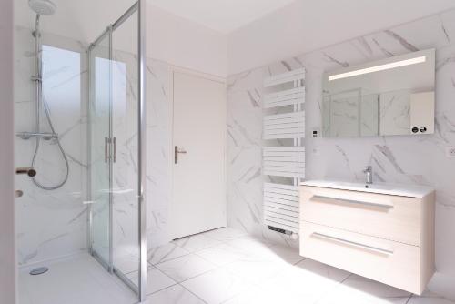 a white bathroom with a shower and a sink at suite Eugénie in Charleville-Mézières