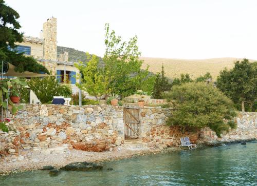 a gate in a stone wall next to a river at blueline guesthouse in Áyios Dhimítrios