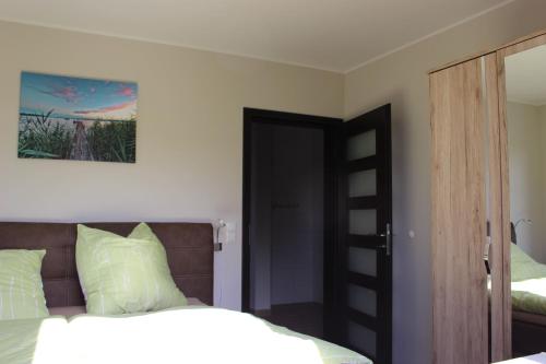 Schlafzimmer mit einem Bett mit weißer Bettwäsche und einem Spiegel in der Unterkunft Lifestyle Ferienhaus in Pouch