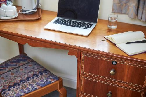 a laptop computer sitting on top of a wooden desk at Yarnfield Park Training And Conference Centre in Stone