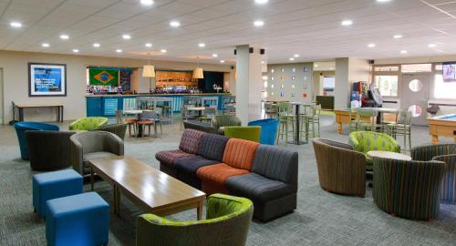 un vestíbulo con sofás y mesas y un bar en Yarnfield Park Training And Conference Centre, en Stone