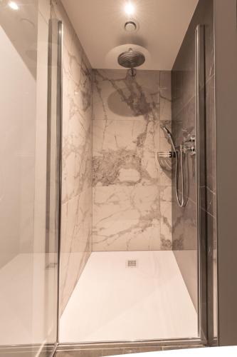a shower with a glass door in a bathroom at Boutique Hotel Sablon by CW Hotel Collection in Bruges