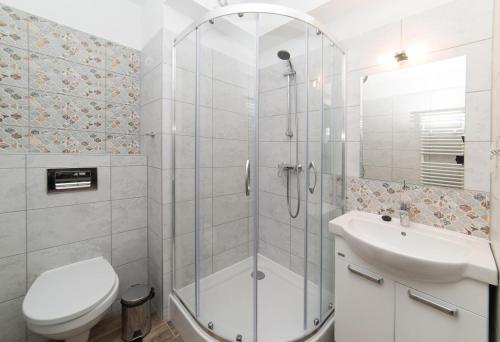 a bathroom with a shower and a toilet and a sink at Apartamenty Ewa II in Ustka