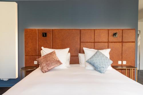 a large bed with white sheets and pillows at Boutique Hotel Sablon by CW Hotel Collection in Bruges