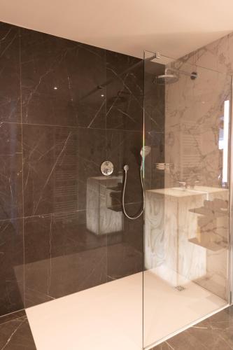 a bathroom with a glass shower with a sink at Boutique Hotel Sablon by CW Hotel Collection in Bruges