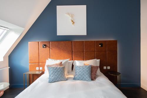 a bedroom with blue walls and a bed with pillows at Boutique Hotel Sablon by CW Hotel Collection in Bruges